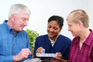caregiver giving medicines to elderly seniors